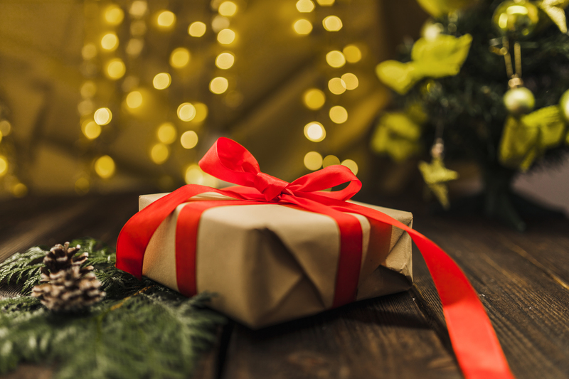 present-box-with-red-bow-near-branch-board